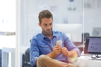 Buy stock photo Shot of a businessman using his cellphone in his office