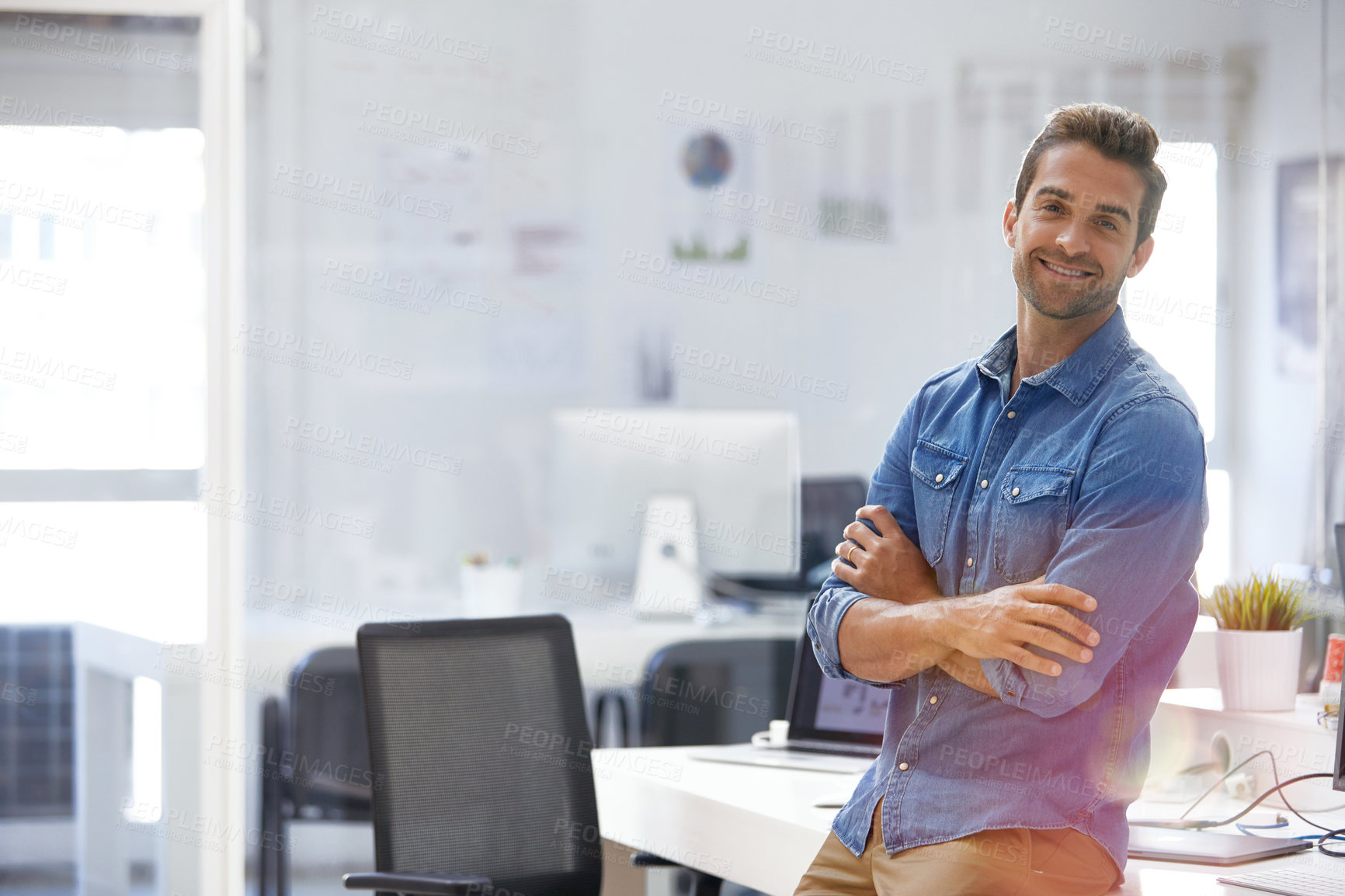 Buy stock photo Shot of a handsome young businessman in his office