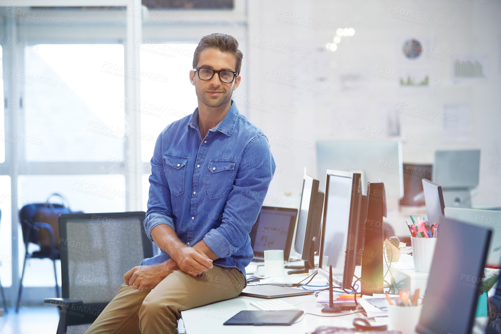 Buy stock photo Shot of a handsome young businessman in his office