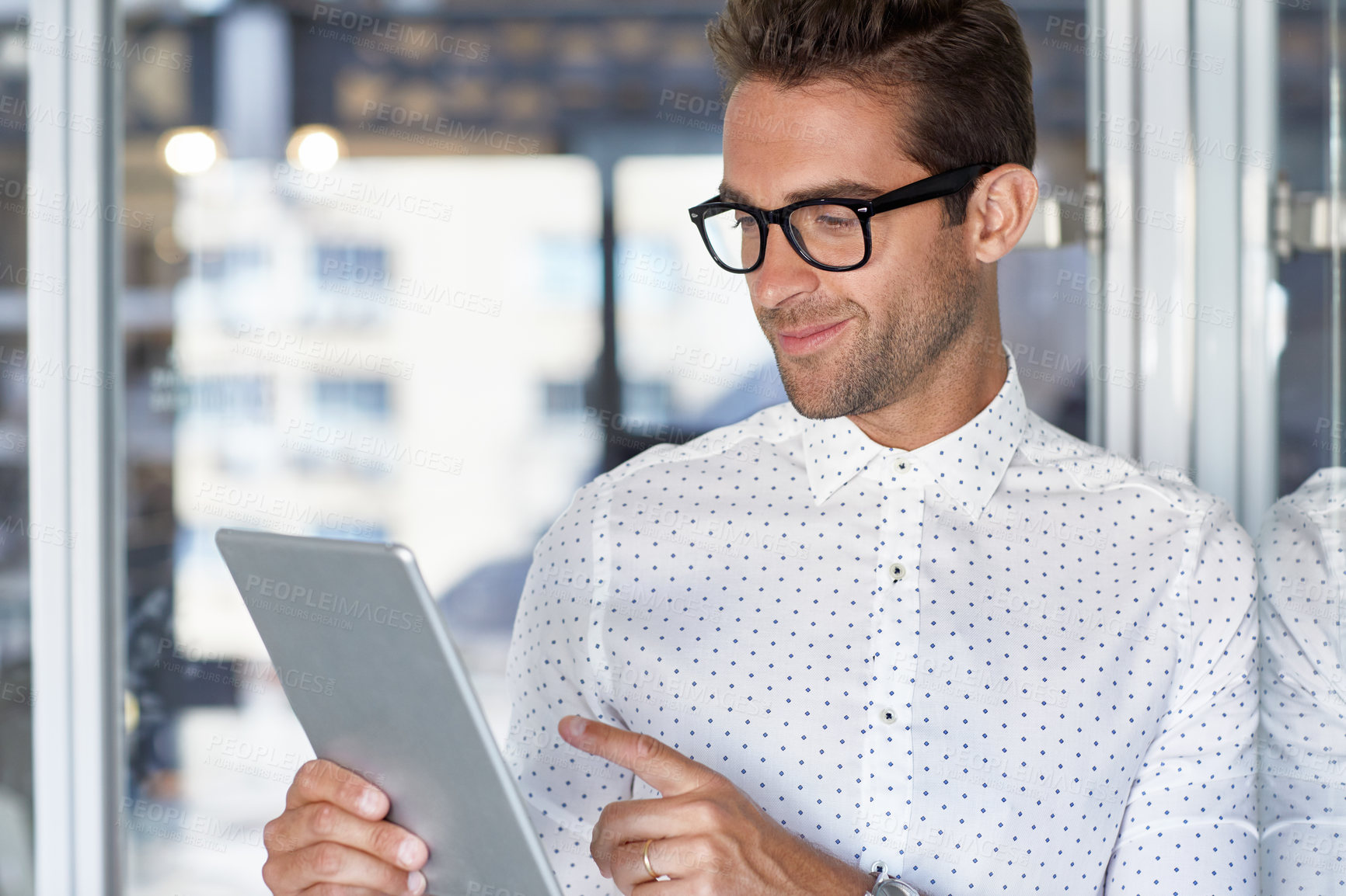 Buy stock photo Cropped shot of a handsome businessman using his digital tablet at work