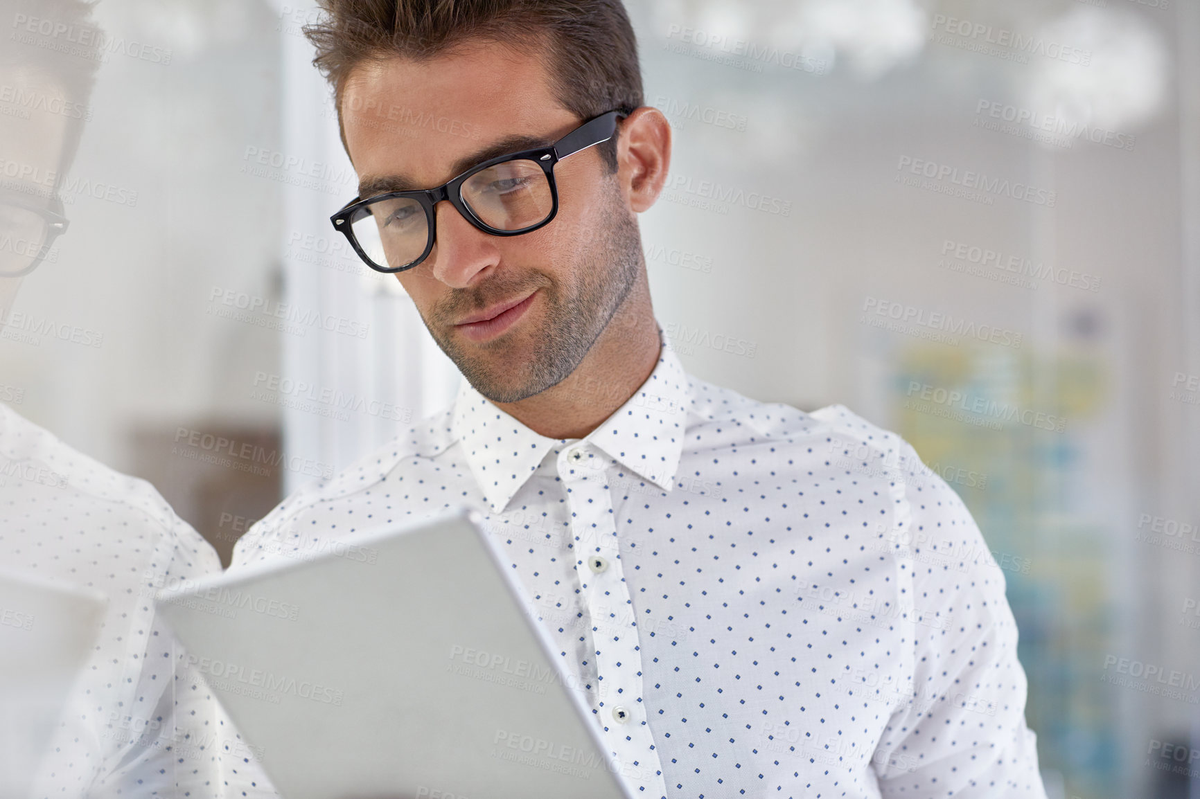 Buy stock photo Cropped shot of a handsome businessman using his digital tablet at work