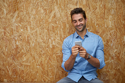 Buy stock photo Shot of a handsome young man posing against a wall