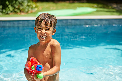 Buy stock photo Portrait of a little boy playing with a water gun in a swimming pool