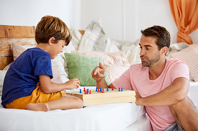 Buy stock photo Shot of a father and son playing a board game in the living room at home