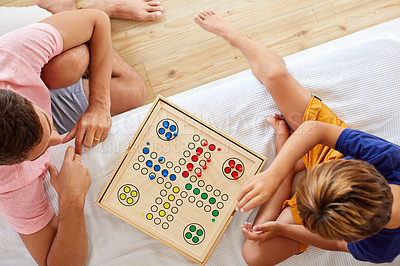 Buy stock photo High angle shot of a father and son playing a board game in the living room at home