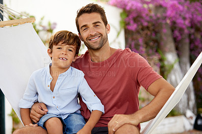 Buy stock photo Portrait of a father and son relaxing together on a hammock outside
