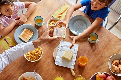 Buy stock photo High angle shot of a young family having breakfast together at home