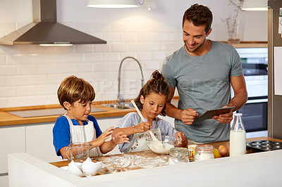 Buy stock photo Cropped shot of a father helping his son and daughter bake in the kitchen at home