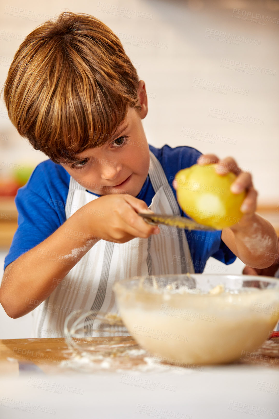 Buy stock photo Cropped shot of a little boy grating lemon zest into batter in the kitchen at home