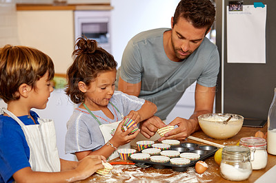 Buy stock photo Cropped shot of a father helping his son and daughter bake in the kitchen at home