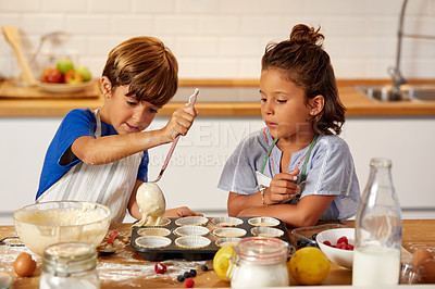 Buy stock photo Cropped shot of a brother and sister spooning batter into a muffin tin in the kitchen at home