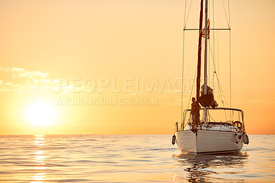 Buy stock photo Shot of a young couple going for an ocean cruise at sunset