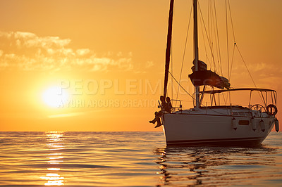 Buy stock photo Shot of a young couple going for an ocean cruise at sunset