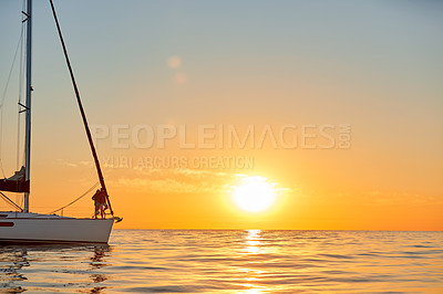 Buy stock photo Shot of a young couple going for an ocean cruise at sunset