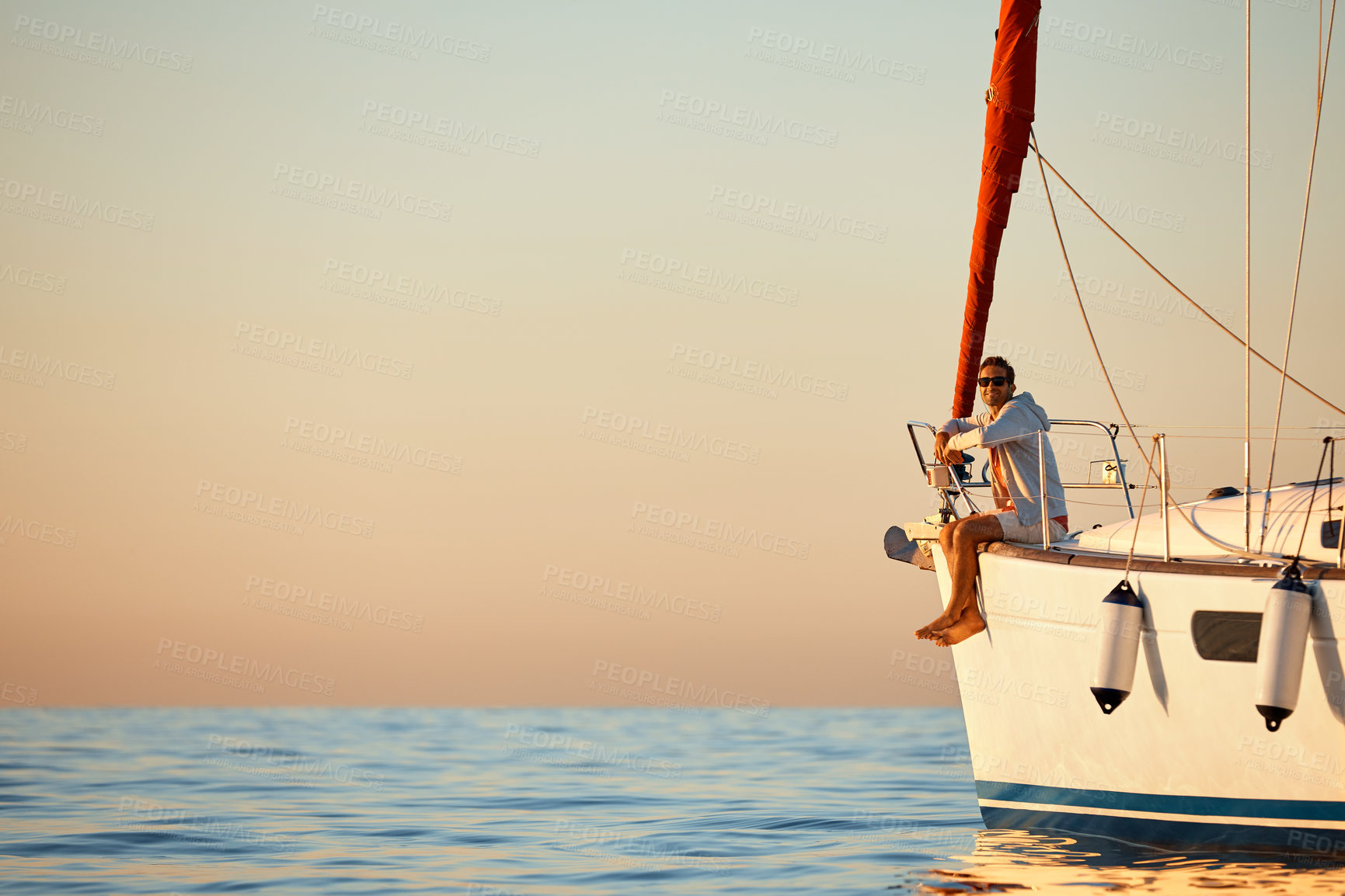 Buy stock photo Shot of a young man going for an ocean cruise on a boat