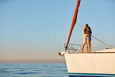 Buy stock photo Shot of a young couple enjoying a cruise out on the ocean