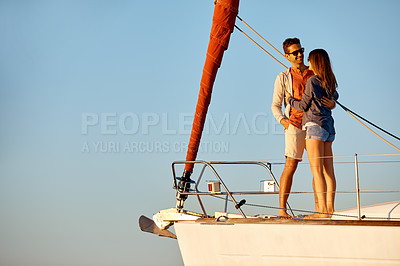 Buy stock photo Shot of a young couple enjoying a cruise out on the ocean