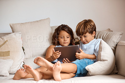 Buy stock photo Shot of a little girl and boy sharing a digital tablet at home
