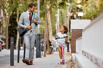 Buy stock photo Shot of a little girl riding her scooter while with her dad by her side