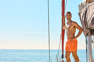 Buy stock photo Cropped shot of a handsome young man standing with his hand on his hip while enjoying a yacht cruise