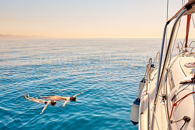 Buy stock photo High angle shot of an affectionate young couple enjoying a swimming during a yacht cruise