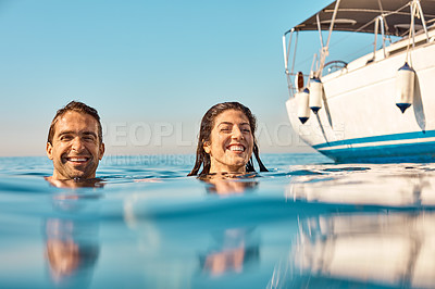 Buy stock photo Cropped shot of an affectionate young couple enjoying swim during a yacht cruise