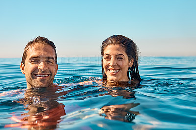 Buy stock photo Cropped shot of an affectionate young couple enjoying swim in the ocean