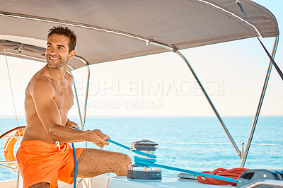 Buy stock photo Cropped shot of a handsome young man captaining his yacht on the open ocean