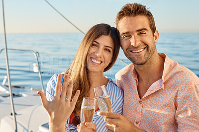 Buy stock photo Shot of a happy young couple getting engaged on an ocean cruise