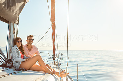 Buy stock photo Shot of a young couple enjoying a cruise out on the ocean