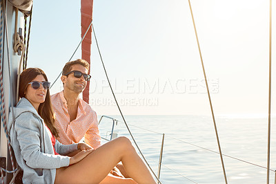 Buy stock photo Shot of a young couple enjoying a cruise out on the ocean