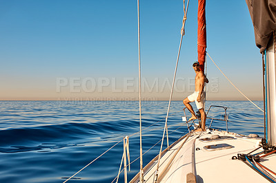 Buy stock photo Shot of a handsome young man going for an ocean cruise on a boat