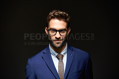 Buy stock photo Studio portrait of a handsome young businessman posing against a dark background