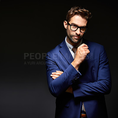 Buy stock photo Studio portrait of a handsome young businessman posing against a dark background