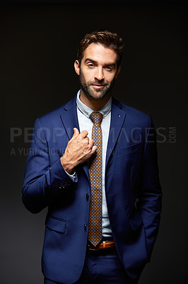 Buy stock photo Studio portrait of a handsome young businessman posing against a dark background