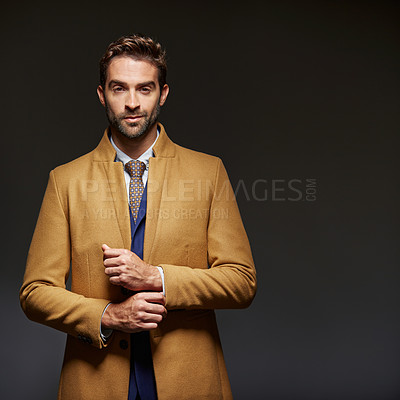 Buy stock photo Studio portrait of a handsome young businessman posing against a dark background