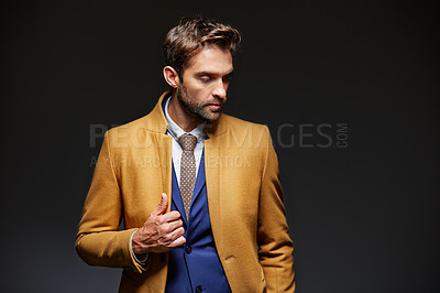 Buy stock photo Studio shot of a handsome young businessman posing against a dark background