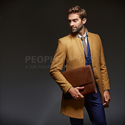 Buy stock photo Studio shot of a handsome young businessman posing against a dark background