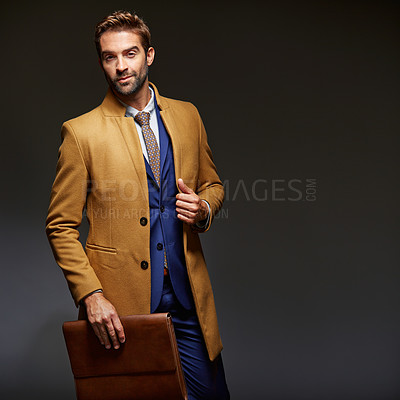 Buy stock photo Studio portrait of a handsome young businessman posing against a dark background