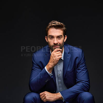 Buy stock photo Studio portrait of a handsome young businessman sitting against a grey background