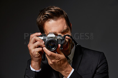 Buy stock photo Studio portrait of a handsome young man taking pictures against a grey background