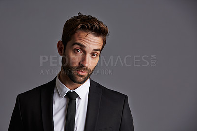 Buy stock photo Studio portrait of a handsome young businessman posing against a grey background