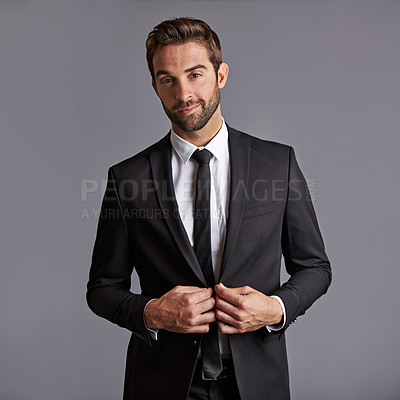Buy stock photo Studio portrait of a handsome young businessman posing against a grey background