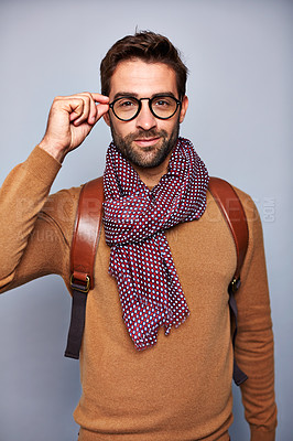 Buy stock photo Studio portrait of a handsome young man adjusting his glasses against a grey background