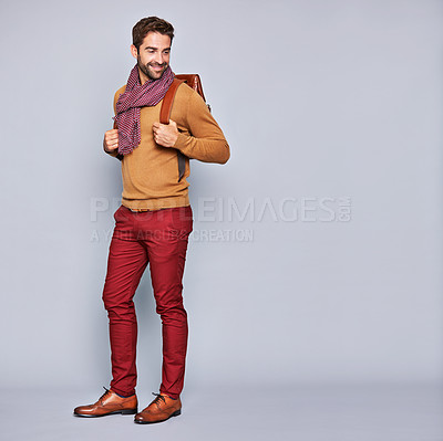 Buy stock photo Studio shot of a handsome young man carrying a backpack against a grey background