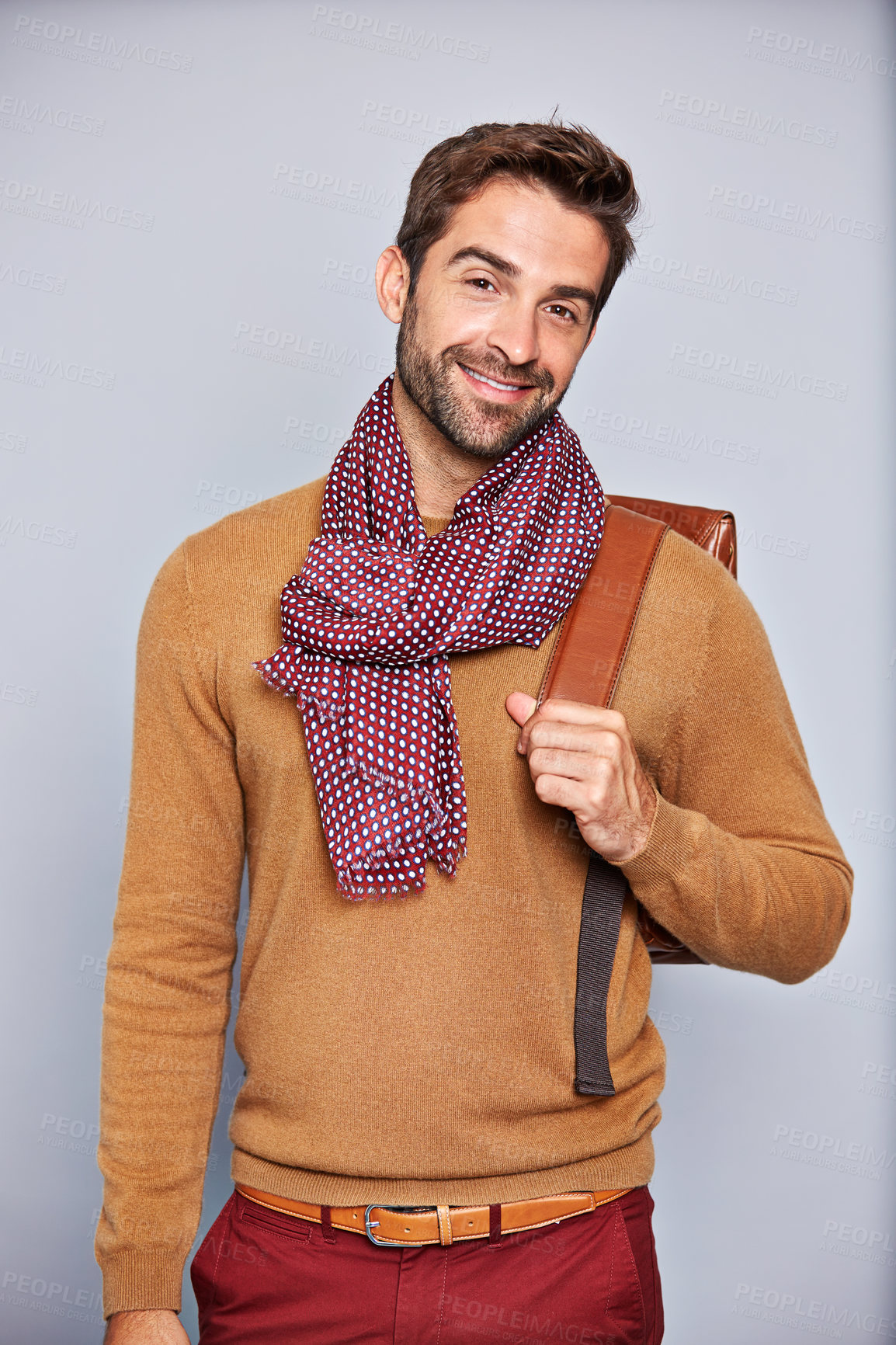 Buy stock photo Studio portrait of a handsome young man carrying a backpack against a grey background