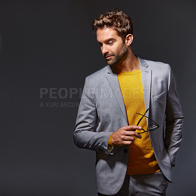 Buy stock photo Studio shot of a handsome young businessman standing against a grey background