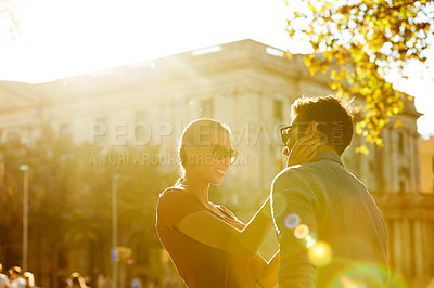 Buy stock photo Shot of a loving couple out in the city on a sunny day