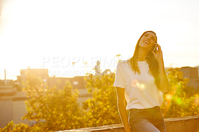 Buy stock photo Shot of a woman talking on her cellphone while standing on a rooftop