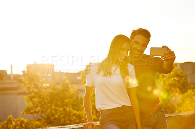 Buy stock photo Shot of a couple taking a selfie while on a rooftop